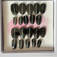 Set of 20 natural short round press-on nails with black gel polish and a pin stripe down the center. 