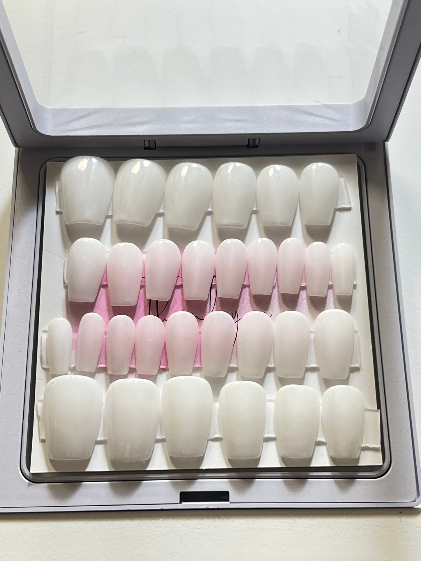 Set of 30 extra short coffin nails with milky white gel polish and no stain top coat. 